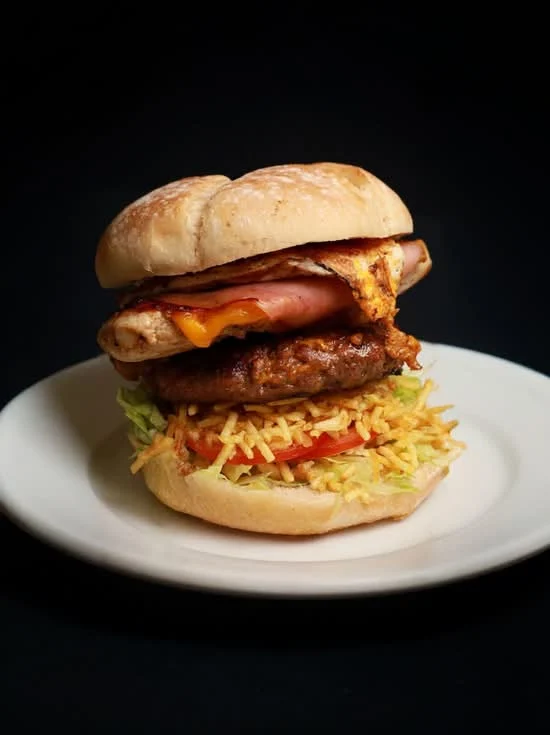 Hamburguesa Triple: pan rústico XL tostado con mantequilla, lechuga, tomate, patatas paja, chuleta…